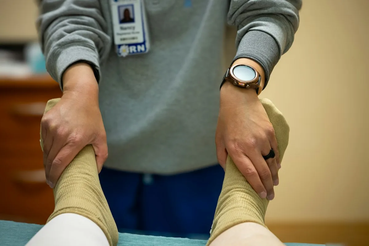 Therapeutin hält beide Füße eines Patienten bei einer angeleiteten Übung